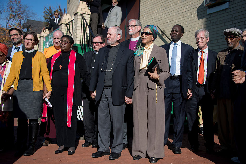 An interfaith coalition of faith leaders stand together holding hands during a press conference on the aftermath of the US presidential election, and rising hate crimes, outside the Masjid Muhammad, The Nation's Mosque, in Washington, DC, November 18, 2016. / AFP / JIM WATSON        (Photo credit should read JIM WATSON/AFP/Getty Images)