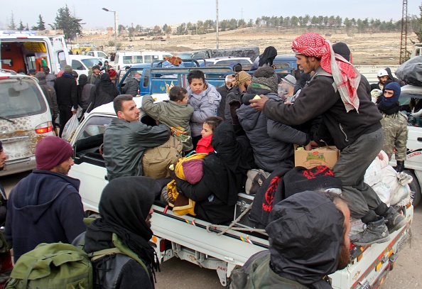 Syrian rebel fighters and civilians who were evacuated from rebel-held neighborhoods in Aleppo arrive in an opposition-controlled region on December 16, 2016.  The Syrian government suspended the evacuation of civilians and fighters from the last rebel-held parts of Aleppo, leaving thousands of people trapped and uncertain of their fate. 