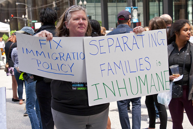 A woman holds signs at a rally in Chicago on June 5, 2018, to protest President Trump's immigration policies. 
