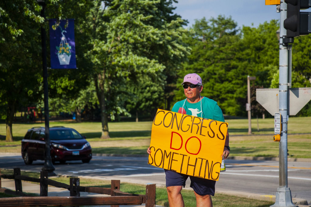 A man holds a sign asking political leaders in Washington to "do something" about gun violence in the wake of the mass shootings in El Paso and Dayton. 