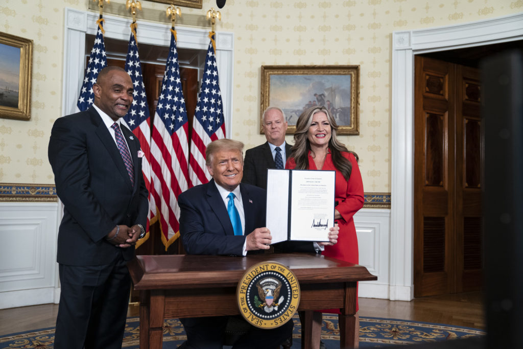 President Trump signs a pardon for ex-convict and Hope for Prisoners CEO Jon Ponder during the Republican national convention. It was one of several events that took place at the White House, raising concerns about violations of the Hatch Act, which prevents the mixing of government functions with partisan political activity. 