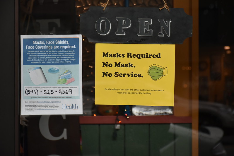 A storefront in Baker City, Oregon displays signs asking customers to follow Covid-19 public health guidance. 