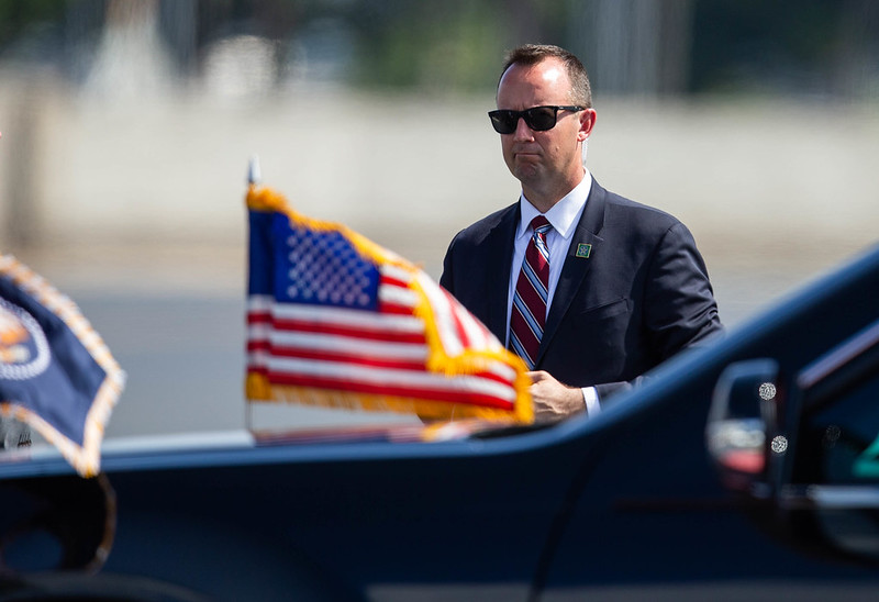 A U.S. Secret Service agent accompanies a presidential motorcade. 