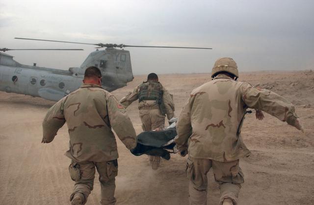 US Army Soldiers rush a wounded soldier to a waiting US Marine Corps helicopter during an operation in Fallujah, Iraq, during Operation IRAQI FREEDOM.