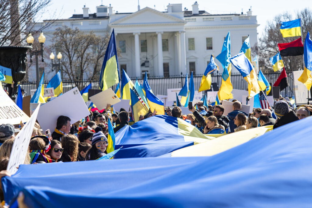 A crowd carrying Ukrainian flags gathers in front of  the White House. In Tuesday's State of the Union speech, President Biden touted the unified allied response to the Russian invasion. 