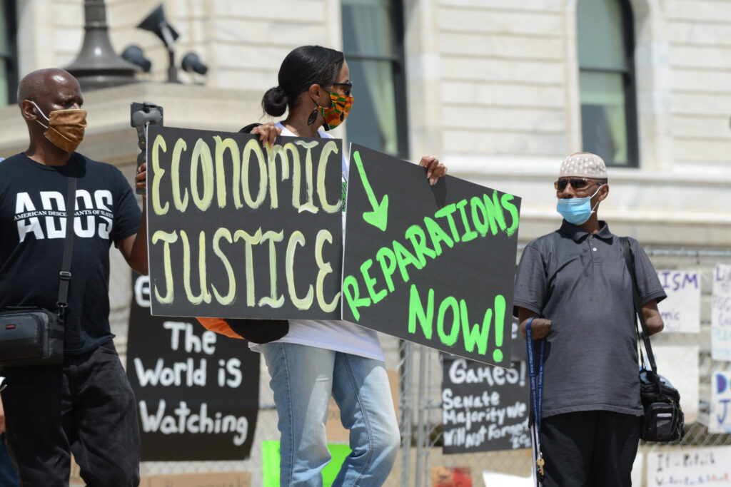 A rally outside the Minnesota capitol building on Juneteenth in 2020 to demand reparations from the United States government for years of slavery, Jim Crow, segregation, redlining, and violence against Black people from police.