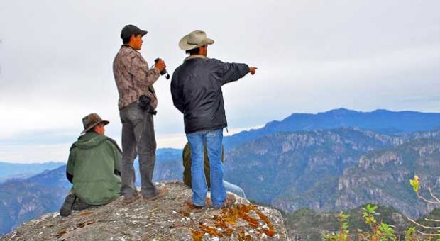 From left to right, Martjan Lammertink, Manuel Escarcega, and Tepehuan guide Rafael look across the vast chasm of Taxicaringa Canyon. The paramilitary drug cartel Los Zetas controls the area on the other side. 