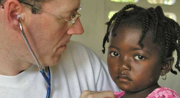 Dr. Paul Farmer, co-founder of Partners In Health, an organization that builds hospitals and provides heathcare to countries afflicted by poor health conditions, attends to one of his patients in rural Haiti. 
