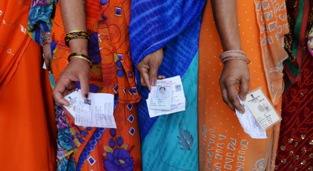 Indian voters pose with their voting slips as they stand in a line to cast their vote outside a polling station at Dabua village on the outskirts of Faridabad on April 10, 2014, during the third stage of voting for national elections in the northern state of Haryana. India's upstart anti-graft party faced a key test as the national capital voted in the first major phase of the country's marathon general elections. The third phase of voting began at 7 a.m.  in 91 constituencies, representing nearly a fifth of the 543-seat lower house, across the capital and 13 other states, including Maoist insurgency-hit eastern India. 
