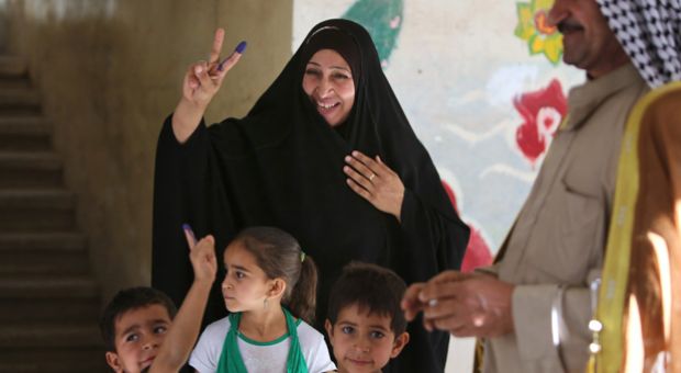 Caption: An Iraqi woman and her children display ink-stained fingers after she cast her ballot in Baghdad's Sadr City district during her country's general elections on April 30, 2014. Iraqis streamed to voting centers nationwide, amid the worst bloodshed in years, as Prime Minister Nuri al-Maliki seeks reelection.  