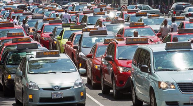 Washington, D.C. taxi drivers park their cars and honk the horn in protest on Pennsylvania Avenue, bringing street traffic to a stop as they demand an end to ride sharing services such as Uber X and Lyft on June 25, 2014, in Washington, D.C.  