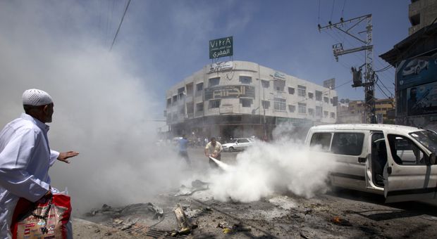 A man uses a fire extinguisher after a vehicle was targeted in an Israeli airstrike on Gaza City on July 8, 2014. An Israeli air strike on a car in Gaza City killed four people, medics said, taking the death toll for the day to five from Israel's air campaign.  
