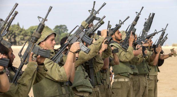 Israeli soldiers check their weapons at an army deployment area, on the southern Israeli border with the Gaza Strip, on August 1, 2014, after the proposed three-day truce collapsed amid a deadly new wave of bloodshed and the apparent capture of an Israeli soldier by Hamas. 