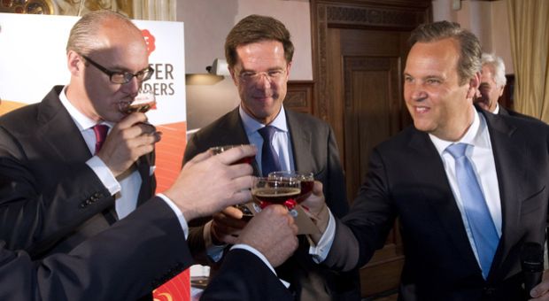 Michiel Herkemij (L), CEO of D.E Master Blenders 1753, a global coffee and tea business, accompanied by Dutch Prime Minister Mark Rutte (C) and CEO of Euronext Cees Vermaas, celebrate after sounding the bell during the opening of trading on the European markets of NYSE Euronext in Amsterdam, on June 12, 2012. The company split from U.S.-based Sara Lee Corp so it could begin trading in Amsterdam.