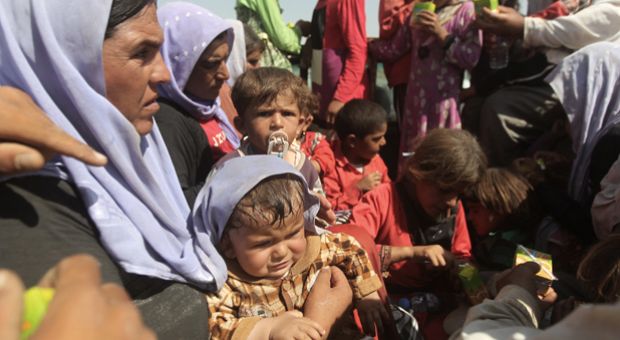 Displaced Iraqi families from the Yazidi community rest after crossing the Iraqi-Syrian border at the Fishkhabur crossing, in northern Iraq, on August 13, 2014. 