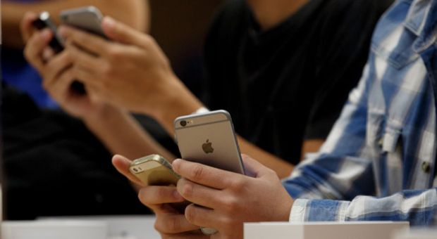 Customers hold their iPhones at Puerta del Sol Apple Store on Sept. 26, 2014 in Madrid, Spain. 