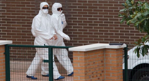 Workers wearing protective clothing walk outside an appartment building, the private residence for Spanish nurse, Teresa R. R who has tested positive for the Ebola virus on Oct. 8, 2014 in Alcorcon, near Madrid, Spain. Spanish Health Minister Ana Mato confirmed nurse, Teresa R. R had tested positive after treating two Ebola patients who had been brought back to the country from Africa. 
