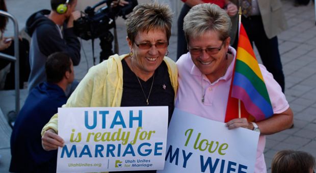 People hold signs and cheer at a same-sex marriage victory celebration on Oct. 6, 2014 at the Salt Lake City Library in Salt Lake City, Utah. The U.S. Supreme Court declined to take up challenges to same-sex marriage making it legal now in Utah. 