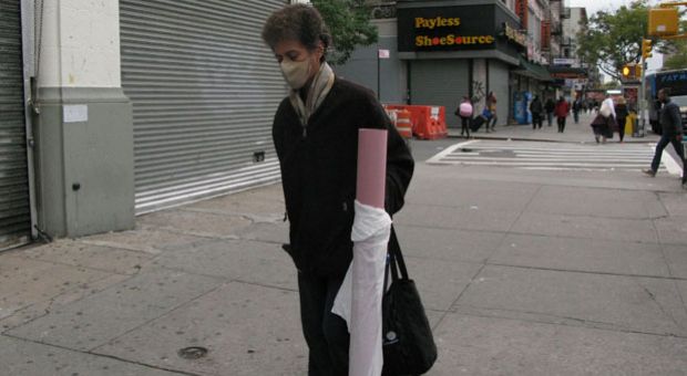 A pedestrian, wearing a mask, walks near the apartment building of Doctor Craig Spencer on October 24, 2014 in New York. Spencer, a member of Doctors Without Borders, who recently returned from treating Ebola patients in Guinea, the epicenter of the world's worst outbreak of the disease, tested positive for Ebola on October 23, making him the city's first Ebola patient.  
