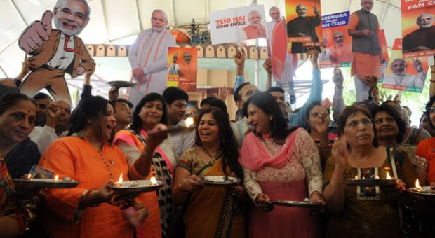 Indian supporters of chief minister of western Gujarat state and main opposition Bharatiya Janata Party (BJP) prime ministerial candidate Narendra Modi sing a prayer hymn during a ritual for Modi's victory at a temple in Ahmedabad on May 15, 2014. India's triumphant right-wing opposition said it was headed for a decisive majority in the world's biggest election after exit polls showed its hardline leader Narendra Modi closing in on victory. 