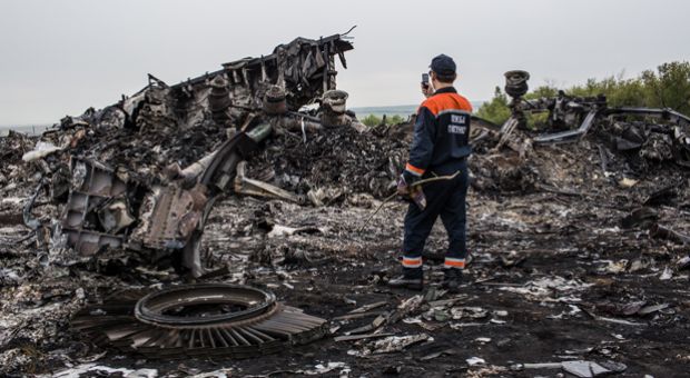 An emergency services worker photographs debris from an Malaysia Airlines plane crash on July 18, 2014 in Grabovka, Ukraine. 
