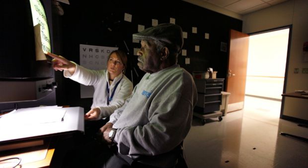 Kristin Reinhart helps Elwood Crowder learn to use a reading aid at the Central Blind Rehabilitation Center at the Edward Hines Jr. VA Hospital  in Hines, Illinois. 