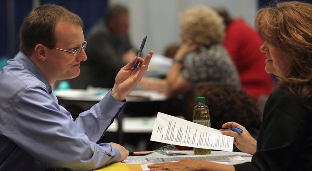 A job-seeker (L), speaks to a counselor a state-sponsored career and job resource fair in Denver, Colorado for the unemployed and underemployed.   