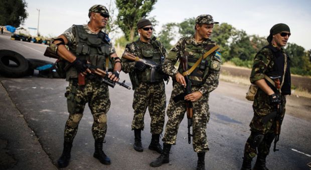 Ukrainian soldiers stand guard at a checkpoint on a road near the city of Dnepropetrovsk on August 25, 2014. Kiev said its forces clashed with an armored column that crossed from Russia, just as Moscow announced plans for a new aid convoy for war-torn east Ukraine.