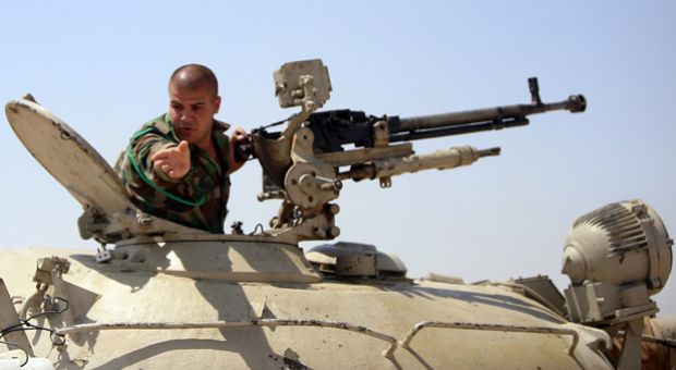 A Peshmerga fighters gestures from an armed military vehicle as he guards a post in the strategic Jalawla area, in Diyala province, which is a gateway to Baghdad, as battles with Islamic State (IS) jihadists continue.