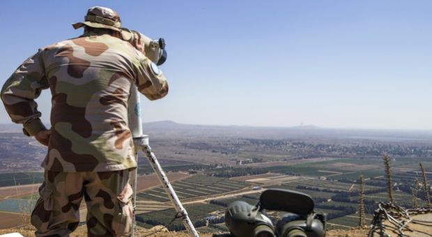 A European member of United Nations Disengagement Observer Force (UNDOF) uses binoculars to watch the Syrian side of the Golan Heights as he stands in the Israeli-occupied Golan Heights on September 5, 2014. Israel is closely monitoring the fighting between Syrian troops and Islamist rebels close to the armistice line on the Golan out of fear of a spillover of the internal conflict.  