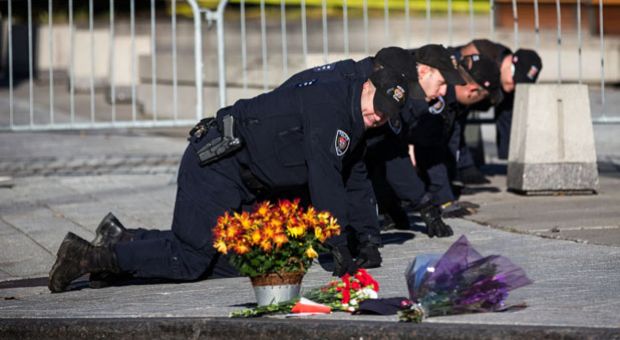 Members of the Ottawa Police sweep the area in front of the National War Memorial one day after a lone gunman killed Cpl. Nathan Cirillo of the Canadian Army Reserves, who was standing guard at the memorial, on October 23, 2014 in Ottawa, Canada. After killing Cirillo the gunman stormed the main parliament building, terrorizing the public and politicians, before he was shot dead. 