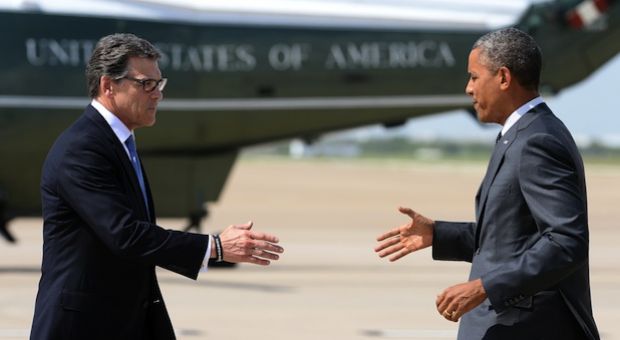 US President Barack Obama (R) is greeted by Texas Governor Rick Perry in Dallas, Texas, on July 9, 2014 as he arrives for a meeting with local elected officials and faith leaders to discuss the urgent humanitarian situation at the Southwest border. 