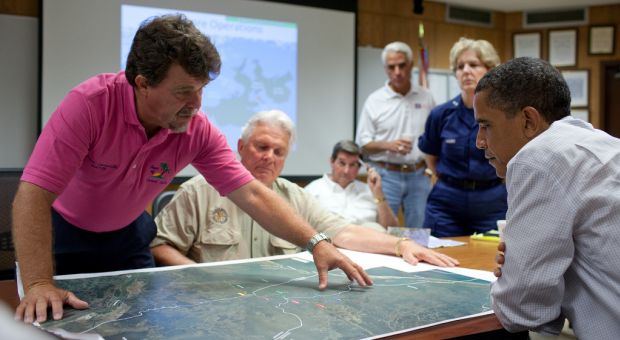 Grand Isle (Louisiana) Mayor David Camardelle points out areas on a map relating to the BP oil spill during a briefing with President Barack Obama at the U.S. Coast Guard Station in Grand Isle, La., May 28, 2010.