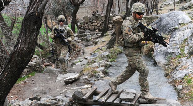Spc. Jesus B. Fernandez crosses a stream during a unit visit to Angla Kala village in Afghanistan's Kunar province, Feb. 6, 2010. International Security Assistance Force troops regularly meet with village elders to improve communications between residents and government officials.