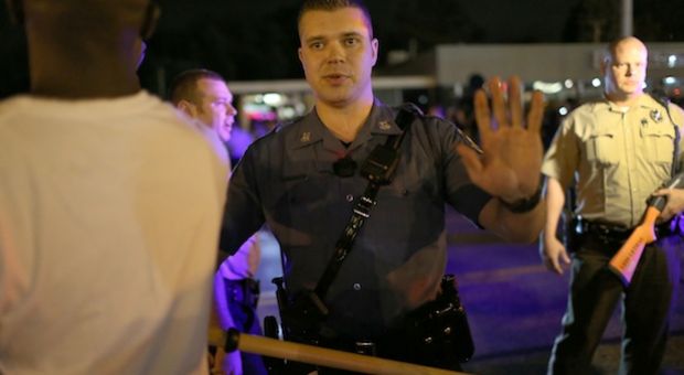 Police officers tell people to back up in Ferguson, Missouri. 