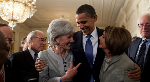 President Barack Obama embraces Secretary of Health and Human Services Kathleen Sebelius, left, and House Speaker Nancy Pelosi after signing the health insurance reform bill in the East Room of the White House, March 23, 2010