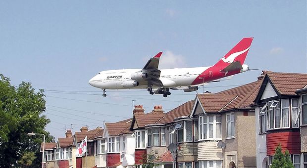 A Qantas Boeing 747-400 approaching runway 27L at London Heathrow Airport, England. The houses are in Myrtle Avenue, at the south east corner of the airport.