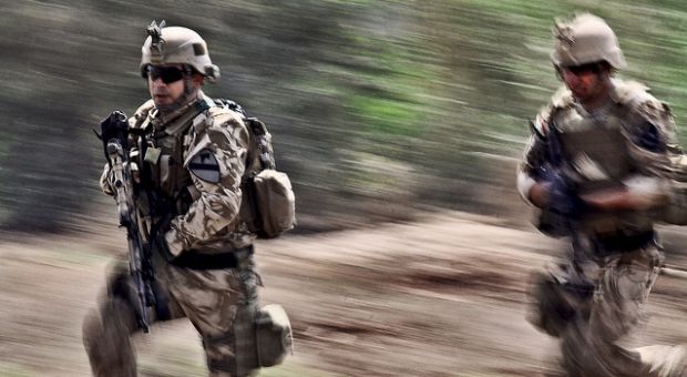 Karkh Area Command Strike Team soldiers rush onto a simulated battlefield during a joint air assault demonstration on Camp Taji, Iraq, March 29, 2010