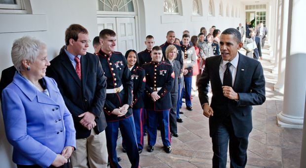 President Barack Obama passes staff from the White House Military Office as he jogs along the Colonnade of the White House following an event that ran late, March 1, 2011. The military personnel and their families were lined up to take departure pictures with the President in the Oval Office.